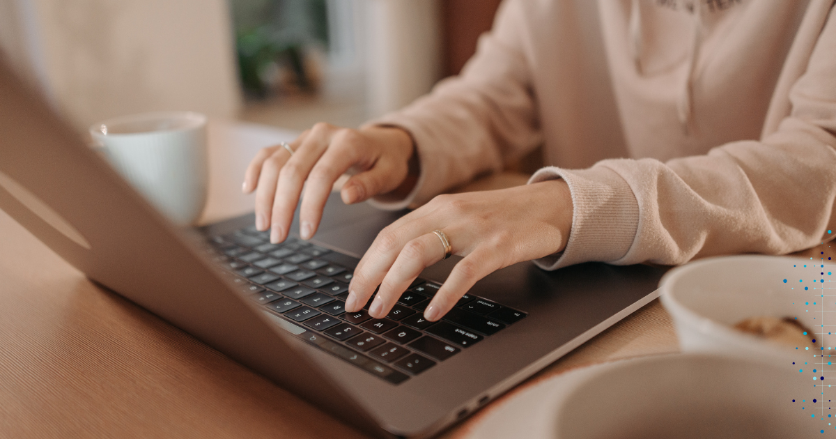 Premium Content Creation - Person typing on laptop with coffee